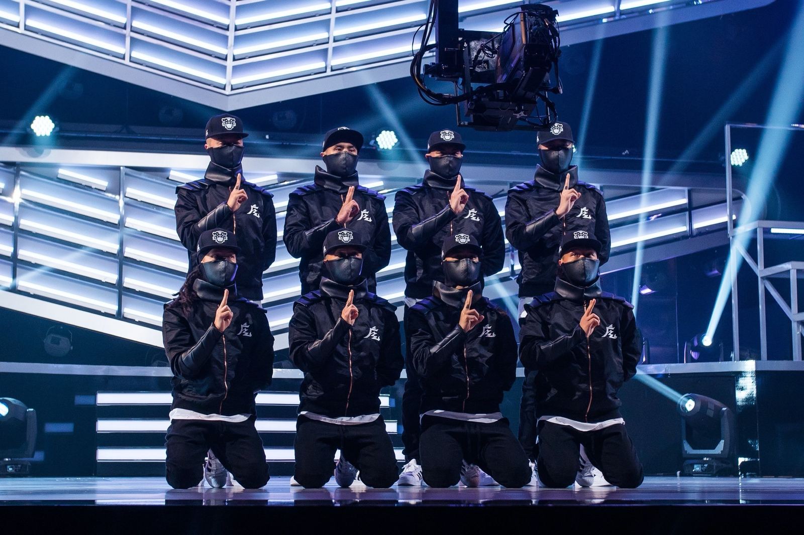 The crew in masks and matching jackets on the America’s Best Dance Crew stage